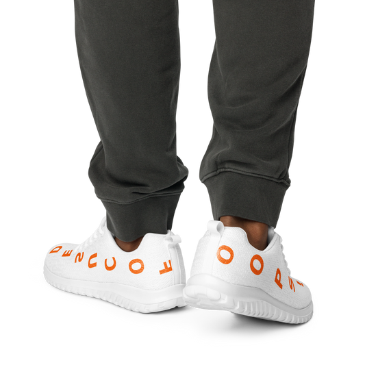 White men’s athletic shoes with orange quote design wrapped around the sole, worn with dark pants. MISITIS™ branding.