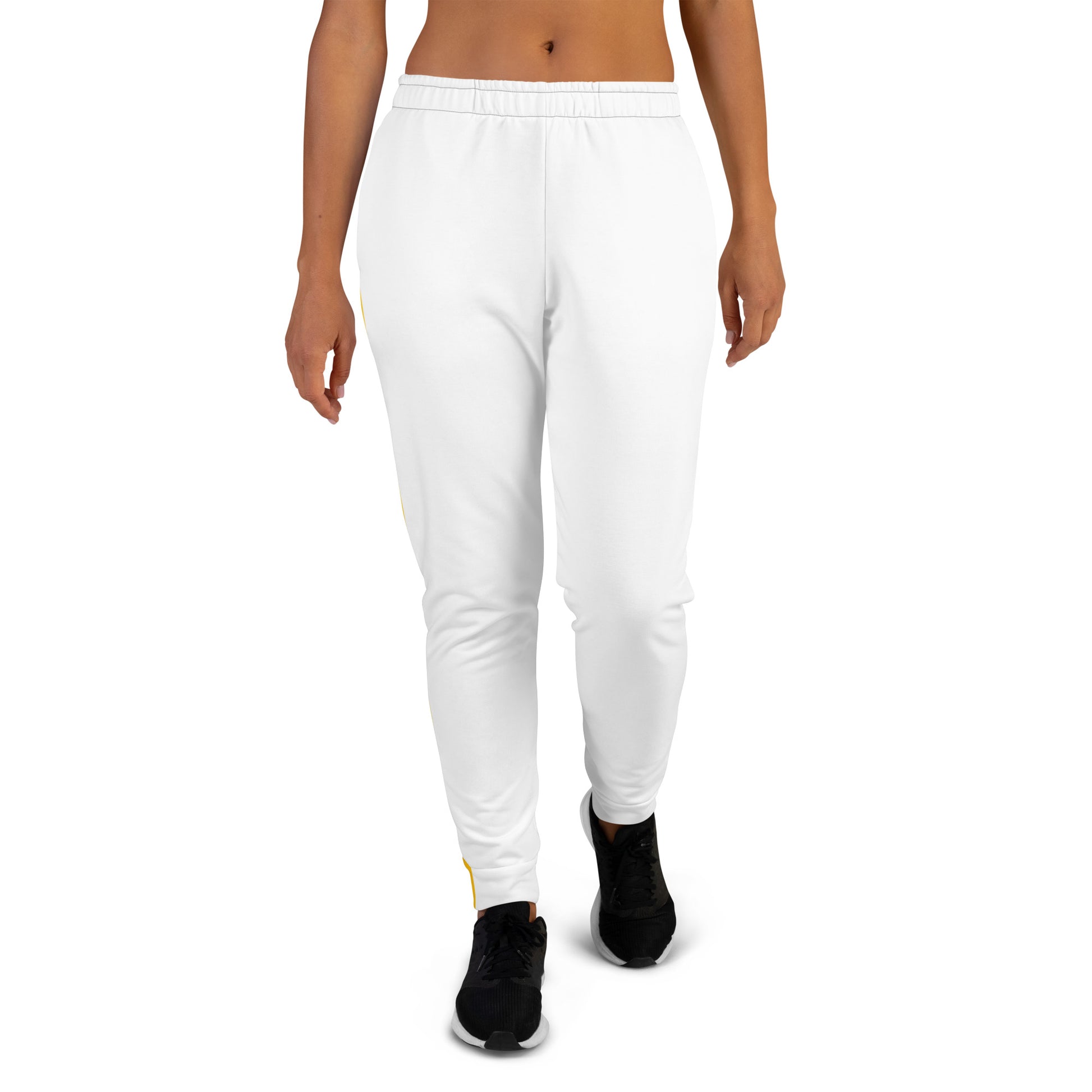 White women's joggers with a tapered fit, elastic waistband, and black sneakers—model shown walking forward on a white background.