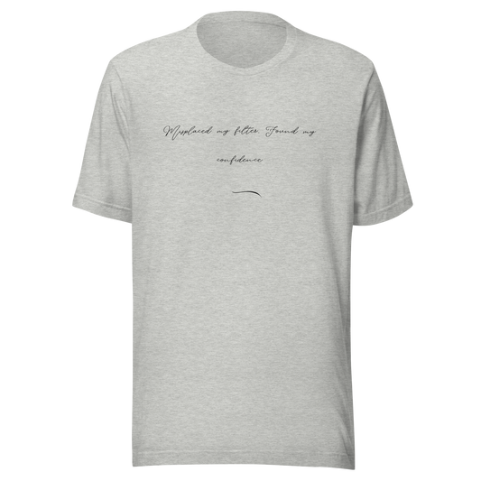 
Close-up of light heather grey MISITIS™ tee with handwritten-style text: "Misplaced my filter. Found my confidence." in black ink
